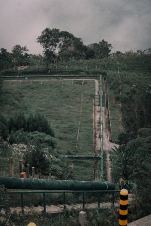 Aerial view of a fenced well site among trees